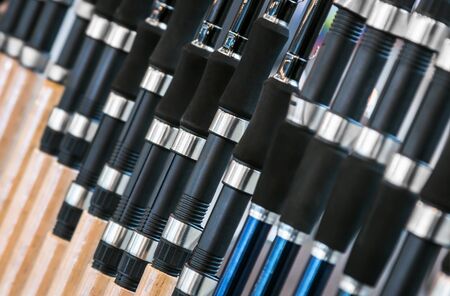 different rods and spinning rods for fishing on the counter in the store. Shallow depth of fieldの写真素材