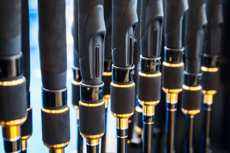 different rods and spinning rods for fishing on the counter in the store. Shallow depth of fieldの写真素材