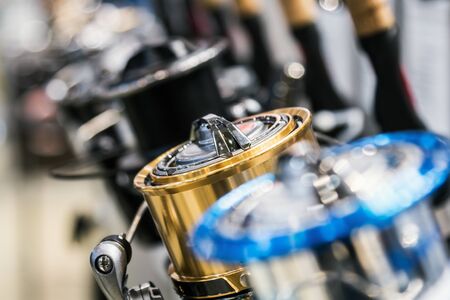 fishing reels of different sizes on the counter in the fishing store. Shallow depth of field