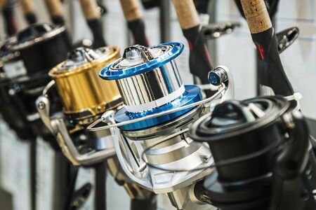 fishing reels of different sizes on the counter in the fishing store. Shallow depth of fieldの写真素材