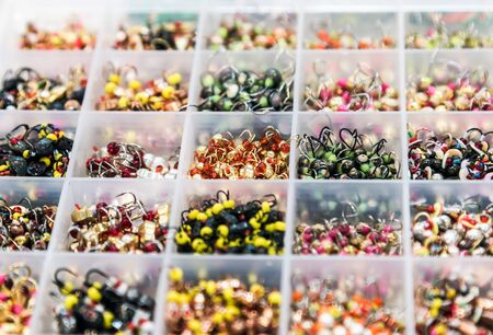 tungsten jig-hooks of different colors, shapes and weights in a box for winter fishingの写真素材