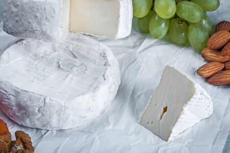 soft brie cheese with grapes, nuts and dried apricotsの写真素材