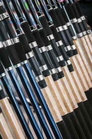 different rods and spinning rods for fishing on the counter in the store. Shallow depth of fieldの写真素材