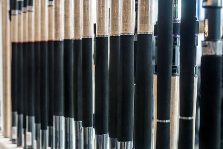 different rods and spinning rods for fishing on the counter in the store. Shallow depth of fieldの写真素材