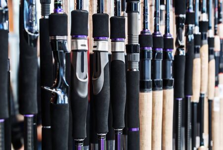 different rods and spinning rods for fishing on the counter in the store. Shallow depth of fieldの写真素材