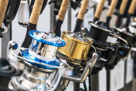 fishing reels of different sizes on the counter in the fishing store. Shallow depth of fieldの写真素材