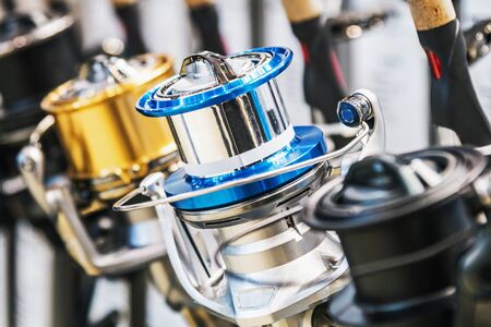 fishing reels of different sizes on the counter in the fishing store. Shallow depth of fieldの写真素材