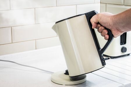  electric kettle in my hand was boiling in the kitchen. Home lifeの写真素材