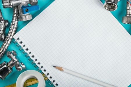 different plumbing and tools with a notebook to write textの写真素材