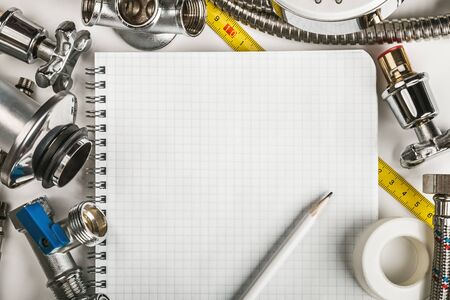 different plumbing and tools with a notebook to write textの写真素材