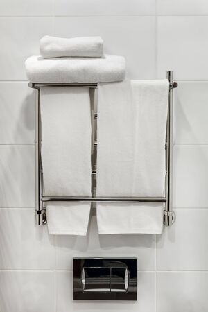 folded bath towels and towels for face and hands on the heating radiator in the bathroomの写真素材