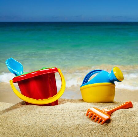children's toys on the sea sand on the background of the sea shoreの写真素材
