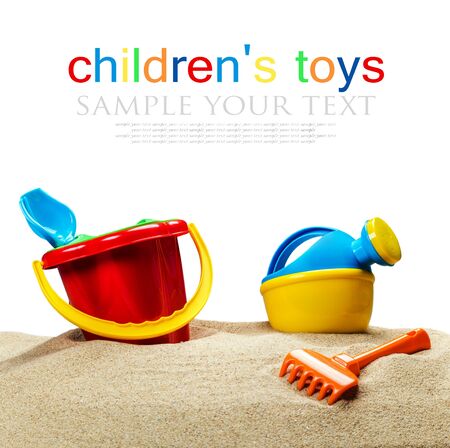 childrens toys, bucket, shovel and race on the sea sand isolated on white backgroundの写真素材
