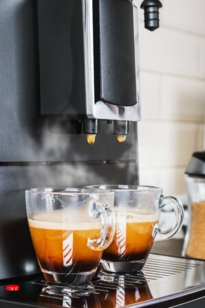 aromatic natural coffee made in a coffee machine. Two cups of hot espressoの写真素材