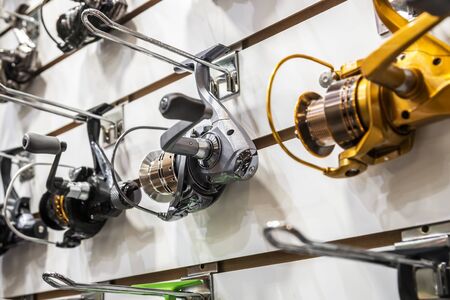 fishing reels of different sizes on the counter in the fishing store. Shallow depth of fieldの写真素材