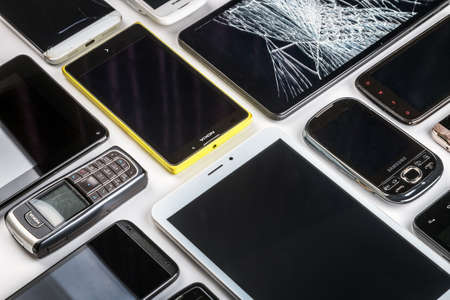 Moscow, Russia-may 19, 2020: outdated and modern models of smartphones, mobile phones and tablets. Background of dirty, broken, tablets and old smartphonesのeditorial素材
