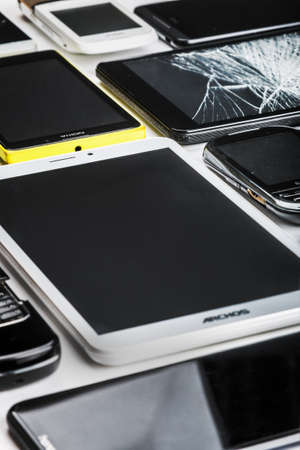 Moscow, Russia-may 19, 2020: outdated and modern models of smartphones, mobile phones and tablets. Background of dirty, broken, tablets and old smartphonesのeditorial素材