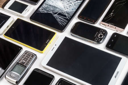 Moscow, Russia-may 19, 2020: outdated and modern models of smartphones, mobile phones and tablets. Background of dirty, broken, tablets and old smartphonesのeditorial素材