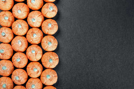small marshmallow pumpkins with a sprinkle of sugar on a black background. Top view with space for your text. Concept for the Halloween holidayの写真素材