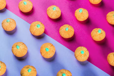 small marshmallow pumpkins with a sprinkle of sugar on a colored background. Decorations for the Halloween holidayの写真素材