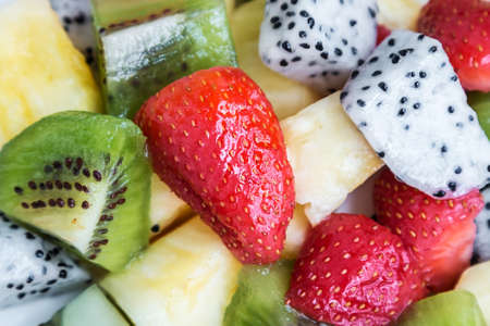 Fresh fruits and berries in the assortment. Background of pineapple, strawberry, dragon fruit and kiwiの写真素材