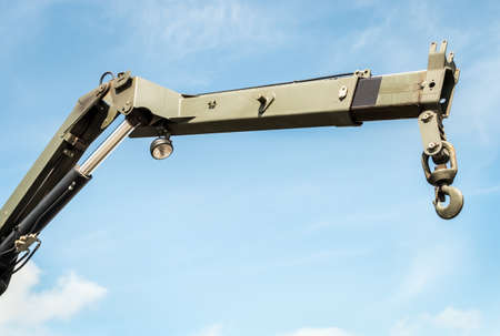 boom and hook of a construction crane on the truck on background of blue sky