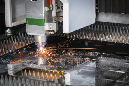 laser cutting and metal sparks processing on a CNC machineの写真素材