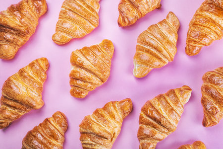 freshly baked croissants lie on a pink backgroundの写真素材