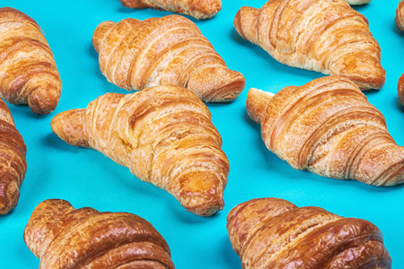 freshly baked croissants lie on a blue backgroundの写真素材