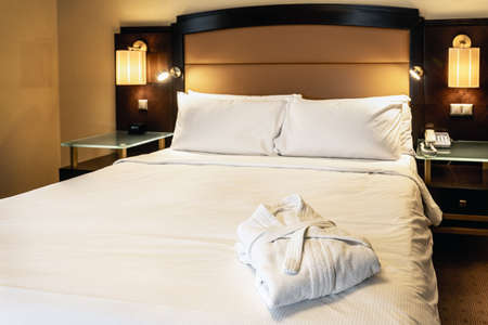 the bathrobes are folded on the bed in the hotel roomの写真素材