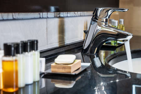 Water flows from the tap in the bathroomの写真素材