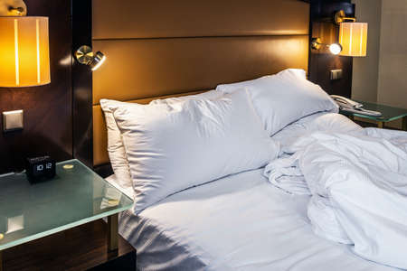 the alarm clock is placed on the bedside table at homeの写真素材