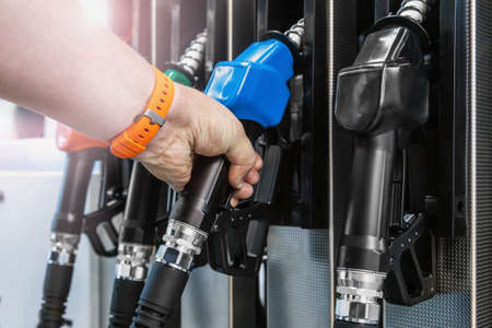 hand holds the filling gun at the gas station and takes it offの写真素材