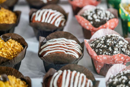 cupcakes and muffins with different flavors, fillings and different sprinklesの写真素材