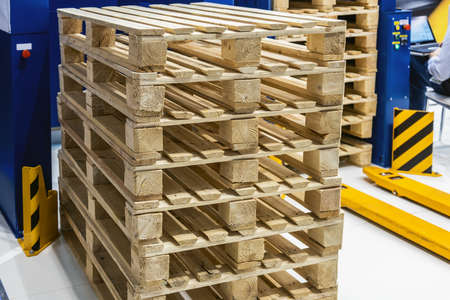 empty wooden pallets stacked in a warehouseの写真素材