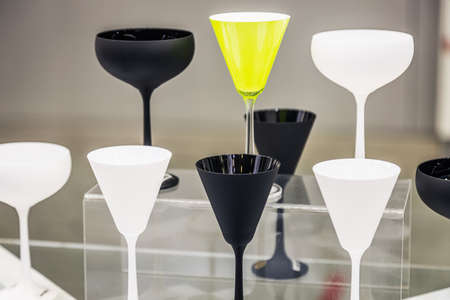 different colored glasses for drinks are on the shelvesの写真素材