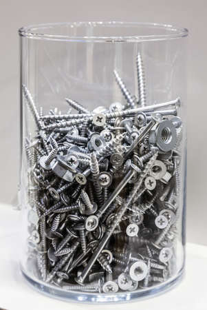 jar with screws on a light backgroundの写真素材