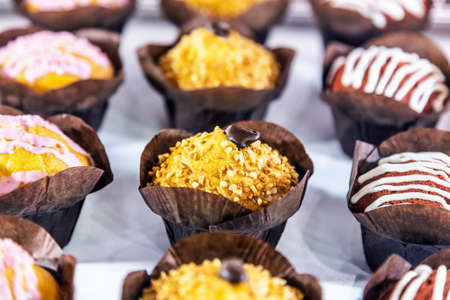 muffins with different flavors, fillings and different sprinklesの写真素材