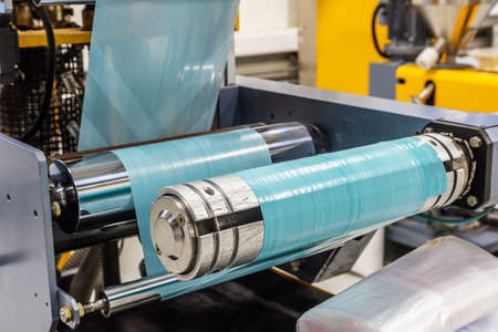 industrial machine with roll of painted plastic filmの写真素材
