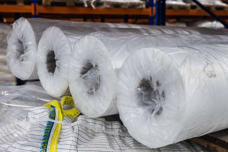 rolls of cellophane lie on the shelves of a large warehouseの写真素材