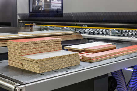 particle boards are stacked on a wood-cutting machine at a furnitureの写真素材
