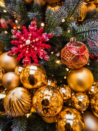 Festive display of gold and red ornaments on a Christmas tree showcasing holiday spirit and decorationの写真素材