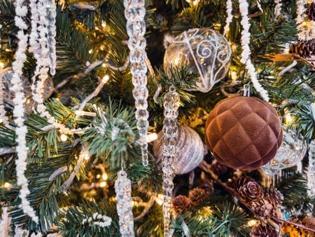 Decorated Christmas tree with sparkling ornaments and shimmering lights during festive celebrationsの写真素材