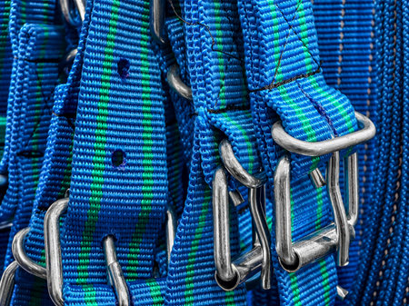 Colorful climbing harness straps and metal carabiners close up showcasing outdoor equipment readinessの写真素材