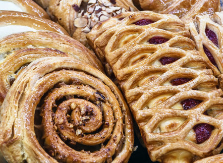 Freshly baked pastries displayed in a bakery showcasing a variety of textures and flavorsの写真素材