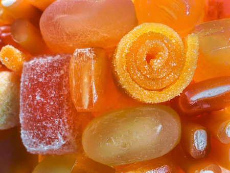 Colorful assortment of various gummy candies in vibrant shapes and sizes captured in close-up during bright daylightの写真素材
