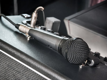Close-up of a microphone resting on audio equipment in a music studio during a recording sessionの写真素材