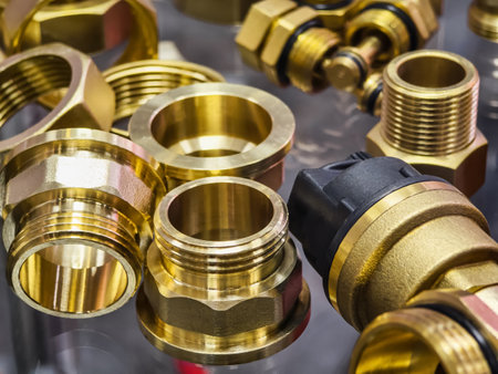 Collection of brass plumbing fittings and connectors arranged on a display surface in a hardware storeの写真素材
