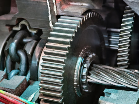 Close-up view of complex mechanical gears and chains in operation inside a machinery setupの写真素材