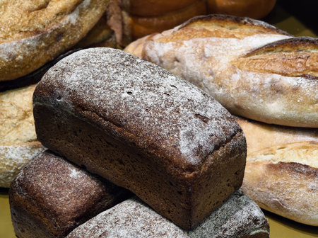 Freshly baked bread in a bakery showcasing various loaves with a focus on rustic textures and artisan craftsmanshipの写真素材